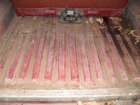 1986 Ford Bronco - The interior cargo area shows a ribbed floor and a fifth wheel hitch, with visible dirt and debris.