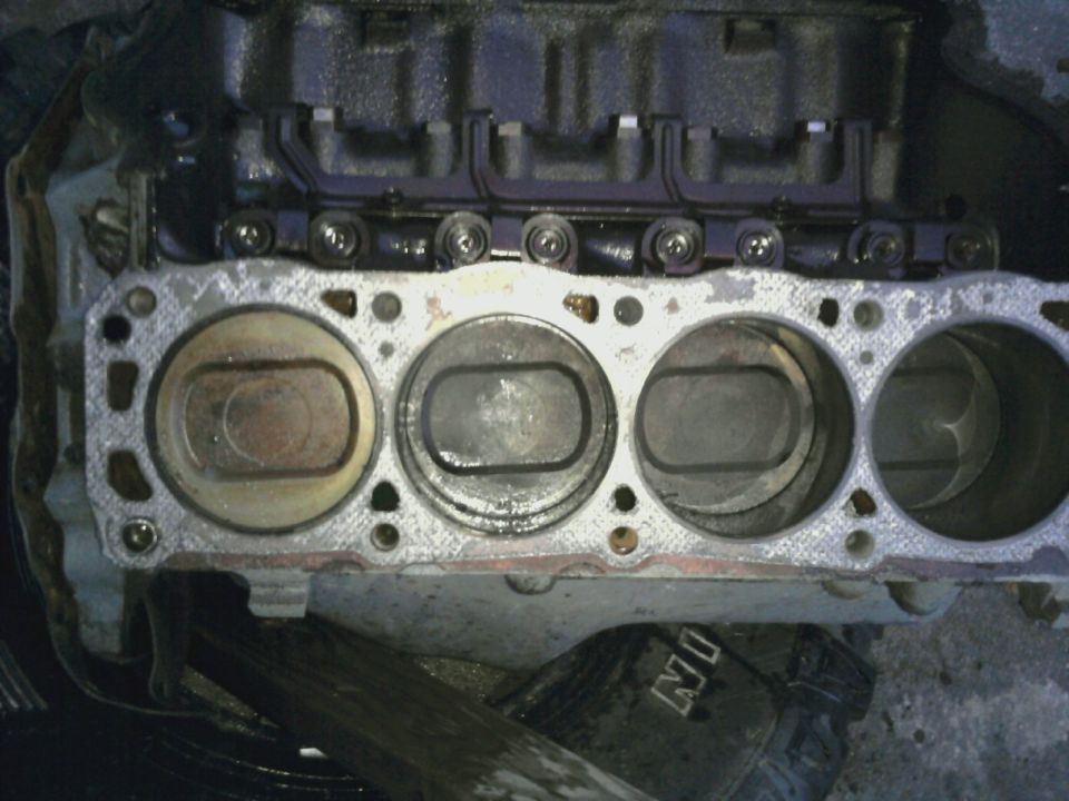 Engine block with pistons visible, showing cylinder bores