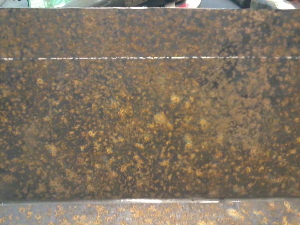 Rusted metal skid plate with a horizontal line etched into it