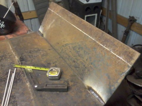 1995 Ford Bronco - A metal part is shown with a tape measure and welding rods, suggesting fabrication or repair work.
