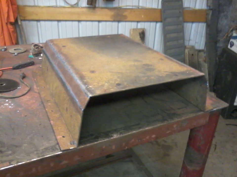 Rusty metal skid plate on a workbench
