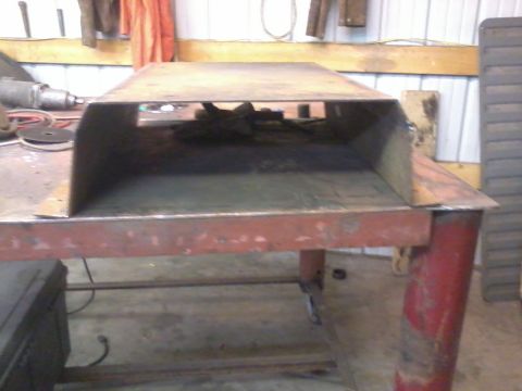 1995 Ford Bronco - Metal skid plate shown on a workbench in a workshop setting.