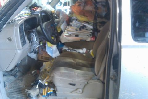 2000 Mercury Grand Marquis - The interior of this vehicle is filled with stacks of papers and various trash items, obscuring most of the dashboard and seats.