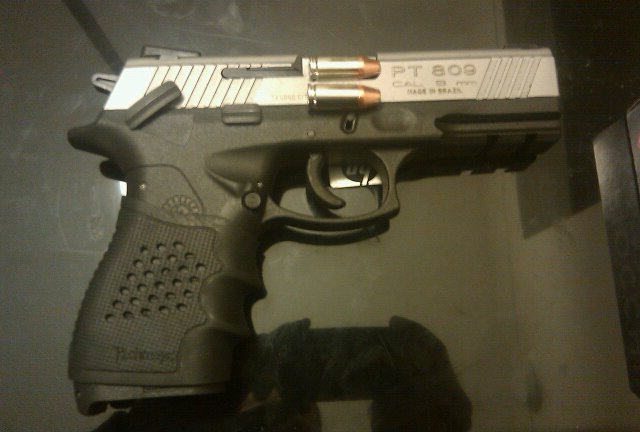 Black pistol with silver slide, loaded with two rounds, marked PT 809