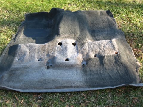 1994 Ford Bronco - Car floor carpet removed from a vehicle, showing wear and tear.