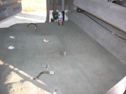 1994 Ford Bronco - Vehicle interior carpet removed, showing floor and a can of spray cleaner.