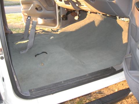 1994 Ford Bronco - The interior carpet of a vehicle is visible, showing the floor and lower door panels.