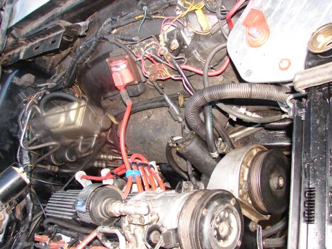 1973 Ford Ranchero - A close-up view of a cluttered vehicle engine bay, showing various electrical components and plumbing.