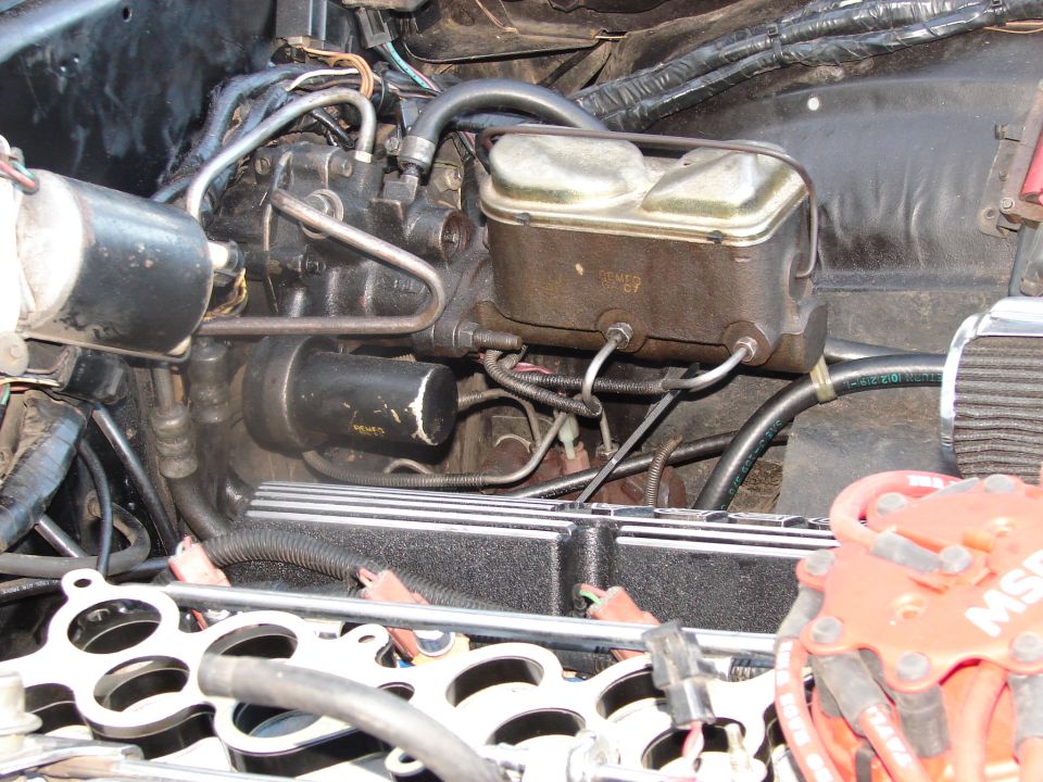 Engine bay detail showing brake master cylinder, brake booster, and part of the engine