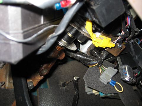 1996 Ford Bronco - Close-up view of the under-dash wiring harness and steering column components, including a yellow airbag connector.