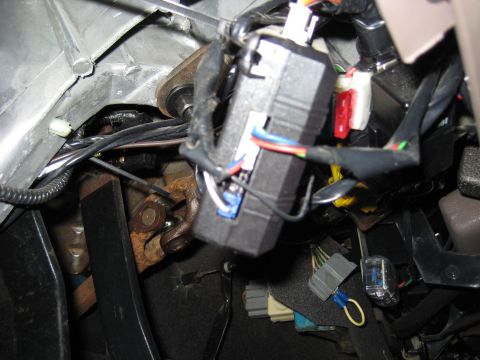 1996 Ford Bronco - Close-up of the wiring harness and a control module located under the dashboard of a 1996 Ford Bronco.