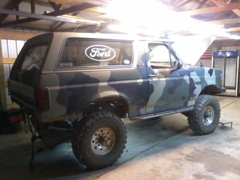 1995 Ford Bronco - This 1995 Ford Bronco features a distinctive camouflage paint scheme and is equipped with off-road tires and a lifted suspension.