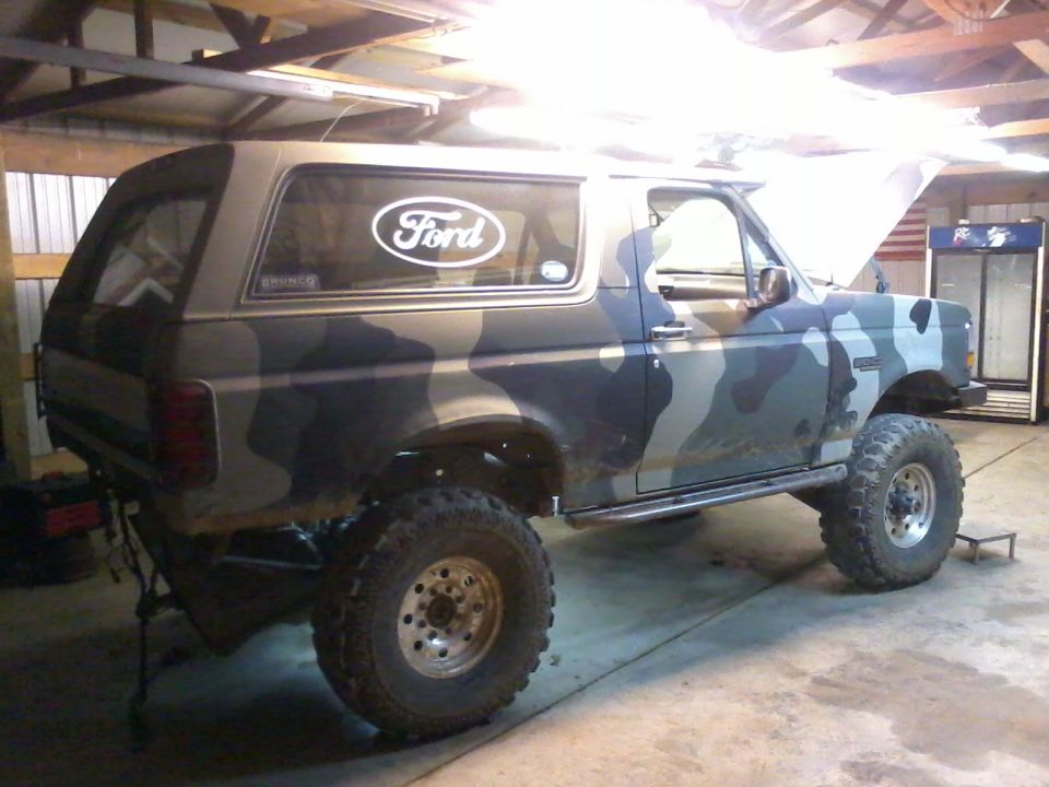 Camouflaged 1995 Ford Bronco with lifted suspension and large tires