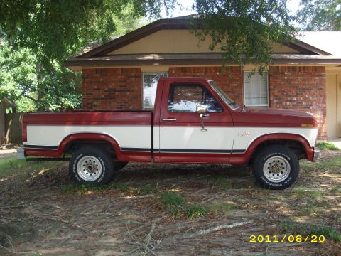 1990 Ford F-150 - Two-tone red and white Ford pickup truck parked in front of a house.