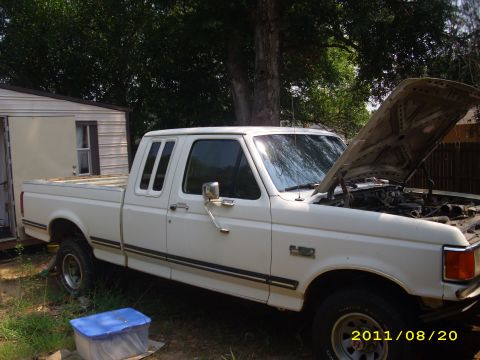1990 Ford F-150 - This 1990 Ford F-150 pickup truck is shown in a three-quarter front view with its hood open, parked outdoors.