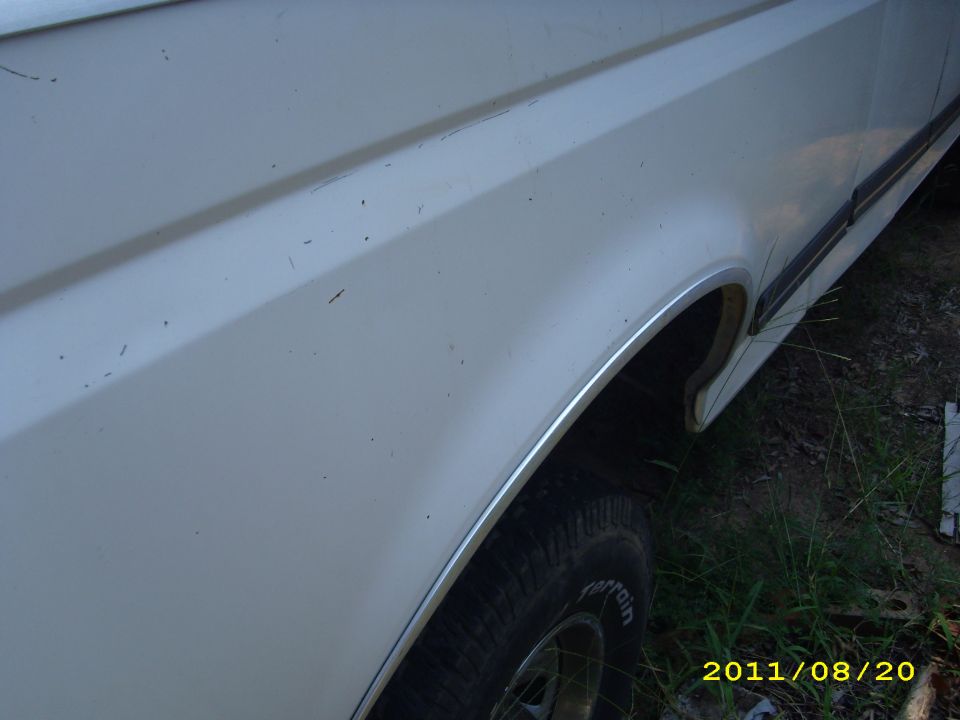 White pickup truck rear fender and tire with chrome trim
