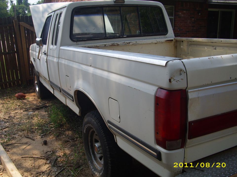 White 1990 Ford F-150 pickup truck with hood open, viewed from the rear quarter angle