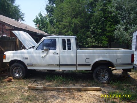 1990 Ford F-150 - Side view of a white 1990 Ford F-150 extended cab pickup truck with the hood open.