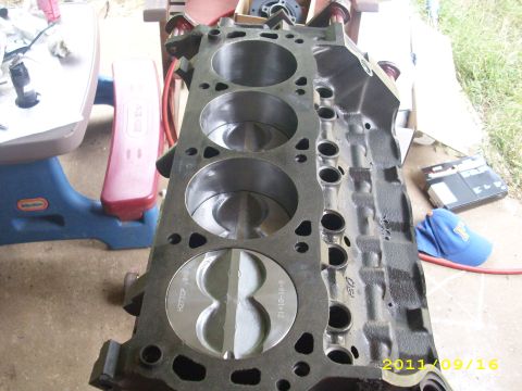 1990 Ford F-150 - Close-up view of an engine block with pistons, revealing part numbers for identification.