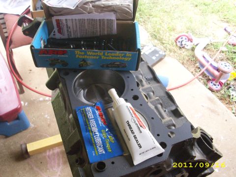 1990 Ford F-150 - Engine block assembly parts including lubricant and thread sealer are laid out.