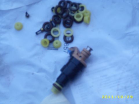 1990 Ford F-150 - Fuel injectors and seals are visible on a blue cloth, with a watermark for Supermotors.net.