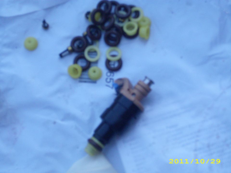 Fuel injectors and assorted seals laid out on a blue cloth