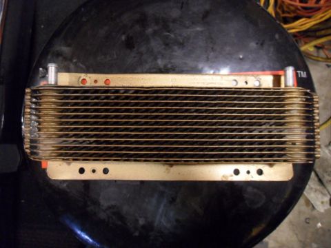 1973 Ford Ranchero - A close-up view of a transmission cooler, showing its intricate fin design and mounting points.