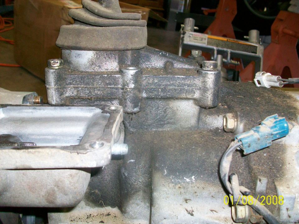 Close-up of a transmission with a shifter boot and electrical connectors