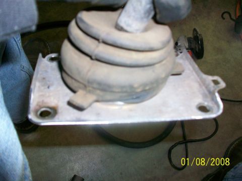 2000 Isuzu Vehicross - Close-up of a vehicle's gear shifter boot and its metal mounting plate, showing wear and dust.