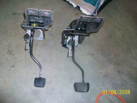 2000 Isuzu Vehicross - Two vehicle pedal assemblies are displayed on a concrete surface, possibly for sale or repair.