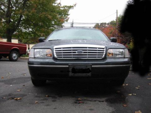 1998 Ford Crown Victoria - Front view of a dark green 1998 Ford Crown Victoria parked outdoors.