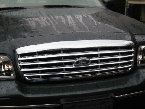 1998 Ford Crown Victoria - Close-up of the front grille and headlights of a Ford Crown Victoria, showing the chrome detailing and Ford emblem.