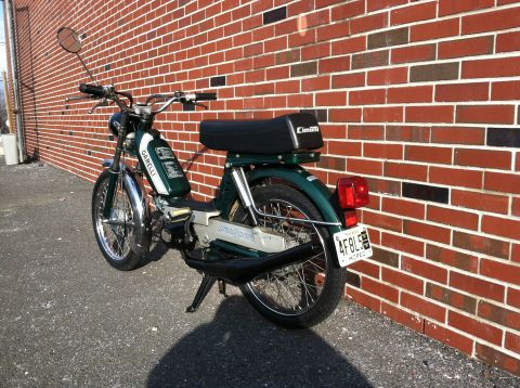 1981 Garelli Rally Sport - A green Garelli moped is parked against a brick wall, showing its side and rear.