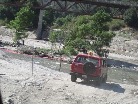 1988 Ford Bronco - This red SUV appears to be from the 1980s, not 1988, as it navigates a dry riverbed.