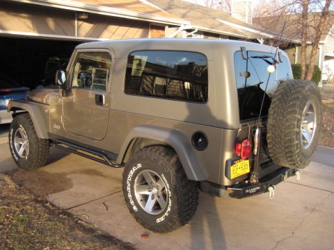 2005 Jeep Wrangler - This 2005 Jeep Wrangler is parked outside a garage, showing its rear and side profile.