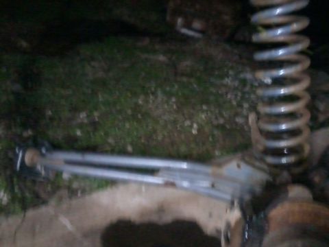 1995 Ford Bronco - A close-up view of a vehicle's suspension system, including a coil spring and control arm.
