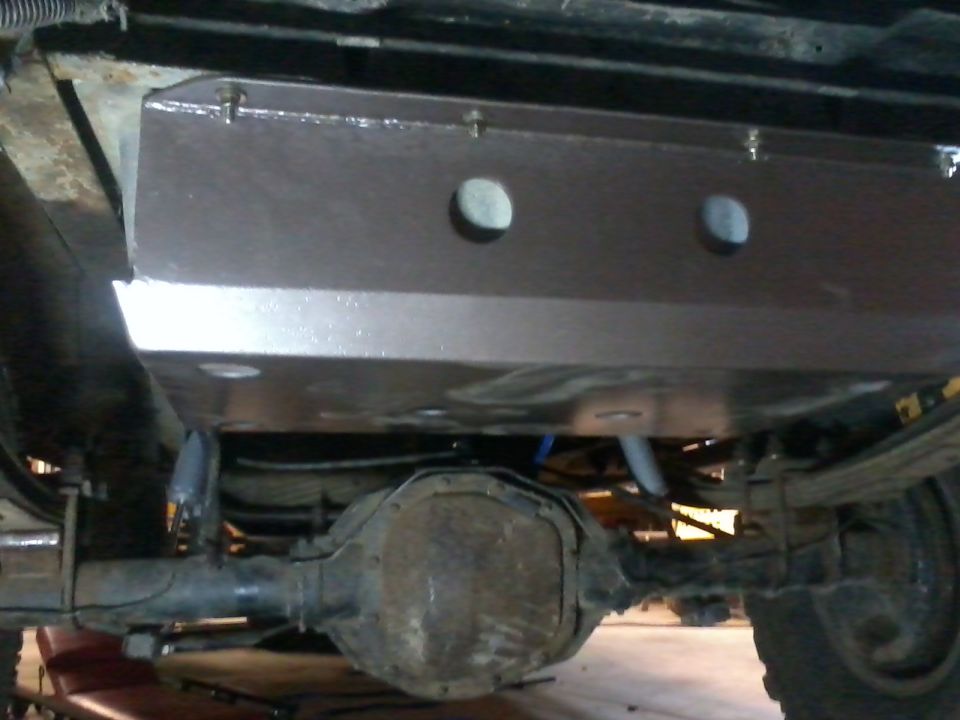 Brown gas tank skid plate over rear axle and suspension components