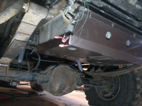 1995 Ford Bronco - Undercarriage view showing a skid plate installed above the rear axle and leaf springs.
