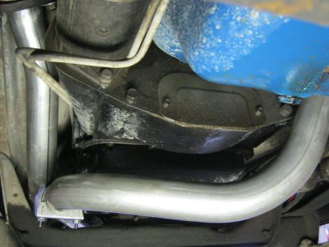 1979 Ford Bronco - Close-up of the exhaust system and transmission components from underneath a vehicle.