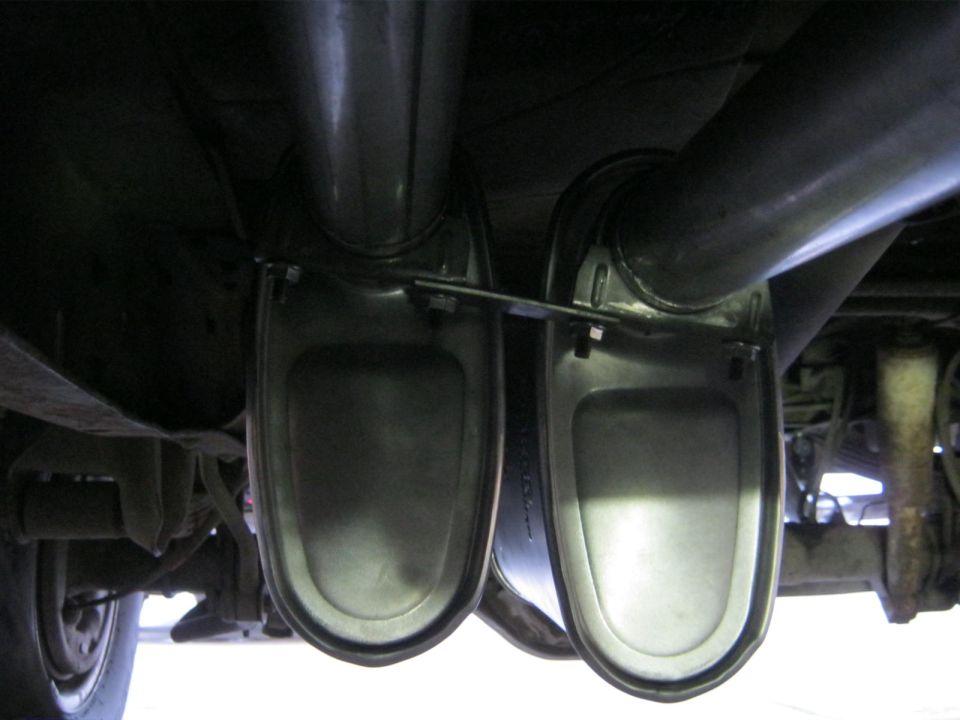 Underside view of dual exhaust mufflers and pipes, with Supermotors.net logo visible