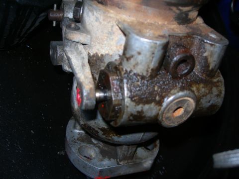 1984 Ford Bronco - Close-up of a greasy, rusty mechanical component with visible bolts and red markings.