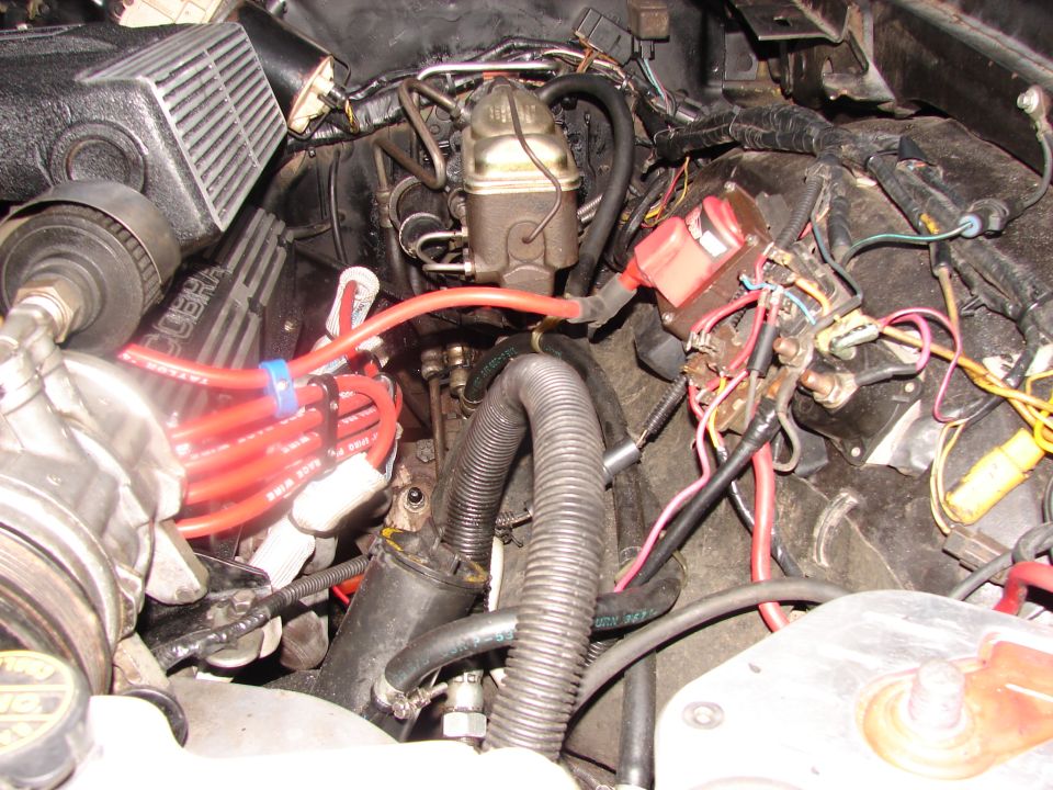 Engine bay detail showing red spark plug wires, brake master cylinder, and "COBRA" lettering on valve covers