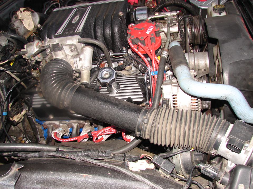 Ford engine bay with MSD ignition wires and ribbed air intake hose