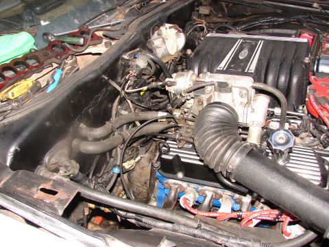 1973 Ford Ranchero - Tools are laid out on the fender of a vehicle's engine bay during maintenance.