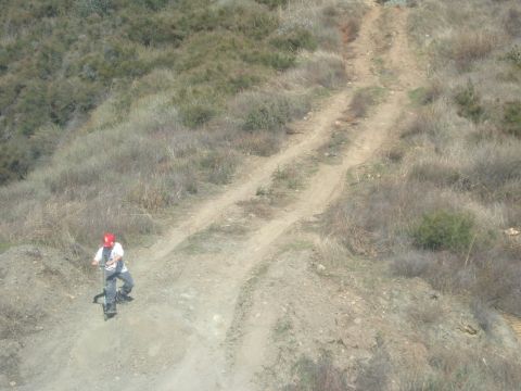 1988 Ford Bronco - Dirt bike rider navigates a steep, dry hillside trail. "SUPERMOTORS" logo visible.