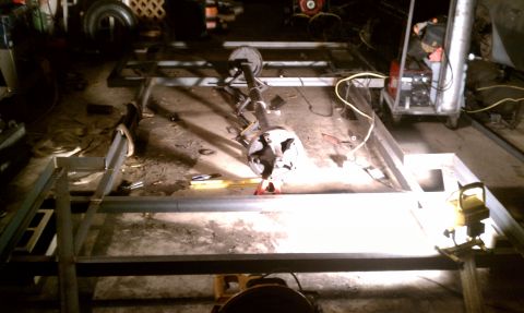 1990 Ford Bronco - Metal frame construction for a trailer, showing an axle assembly and welding equipment.