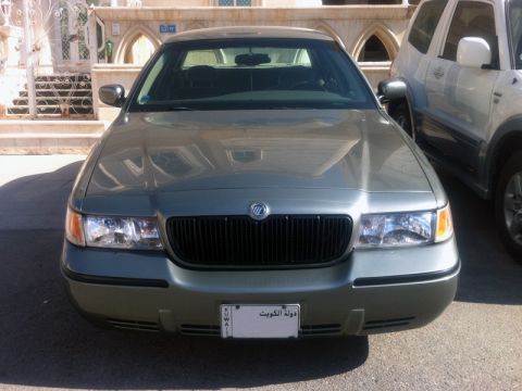 2001 Mercury Grand Marquis - This Mercury Grand Marquis is parked in front of a building with an SUV to its right.