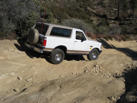 1996 Ford Bronco - White 1996 Ford Bronco navigating an off-road path.