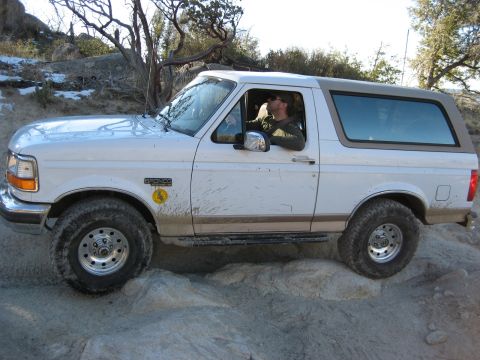 1996 Ford Bronco - A 1996 Ford Bronco navigates a rocky trail with a driver behind the wheel.