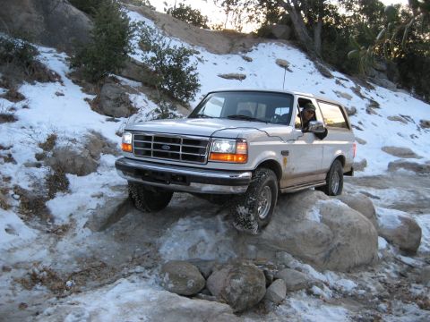 1996 Ford Bronco - A 1996 Ford Bronco navigates a rocky, snow-covered trail.